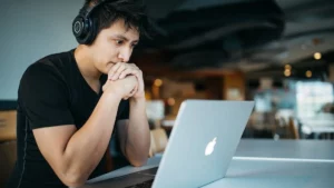 programmer in Wireless Headphones Work on Laptop